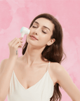 A young woman gently using the MoonGlow Skin Brush on her face, demonstrating its ergonomic design and skin care benefits.