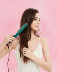 Model using the Nora Pro Straightener, straightening her hair for a sleek and smooth look.